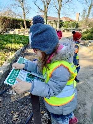 Dziewczynka ogląda tablicę informacyjną w parku.